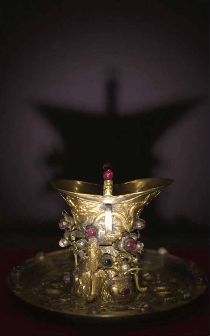 Intricate gold vessel casting dramatic shadow