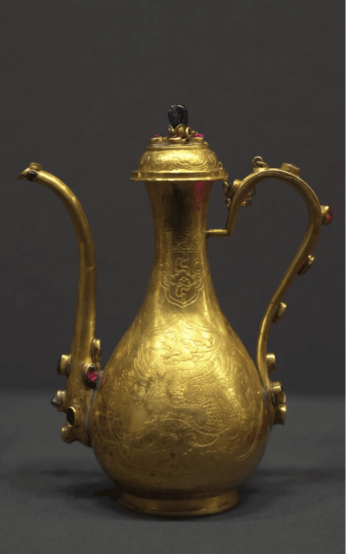 Intricate golden ewer with gemstones.