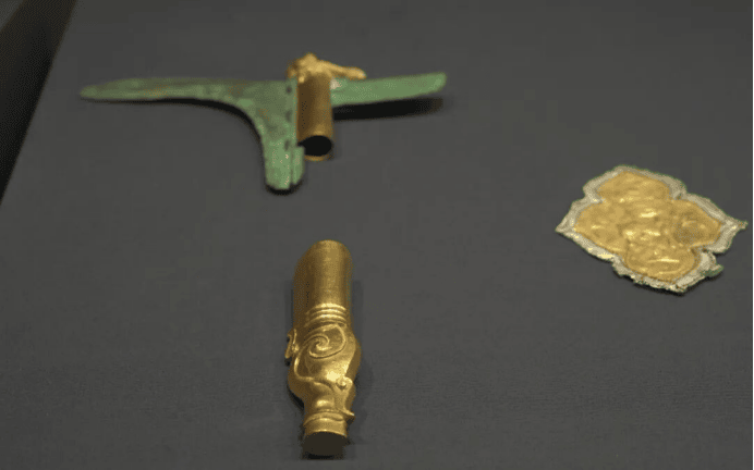 Ancient gold and bronze artifacts displayed.