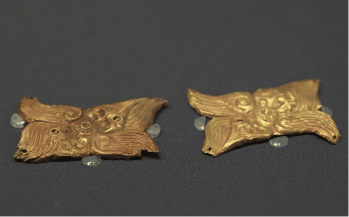 Ancient gold decorative artifacts displayed elegantly.