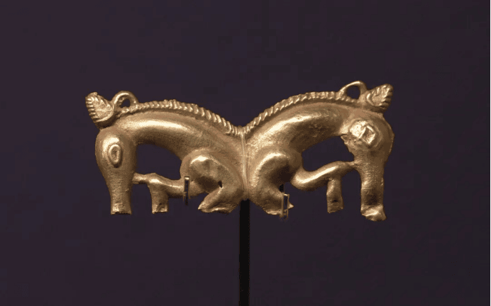 Intricate gold ornament depicting two horses