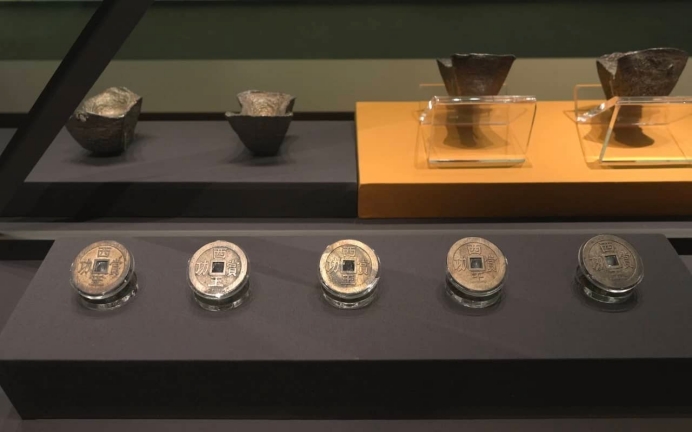 Ancient coins displayed in glass cases.