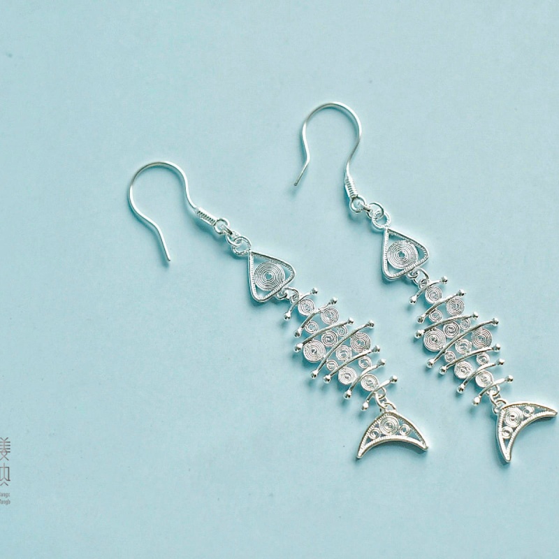 Elegant fishbone silver earrings on model
